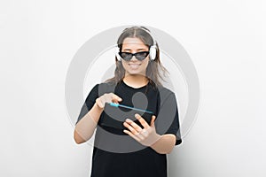 Smiling girl listening to the music is playing on her tablet on white background.