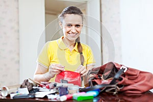 Smiling girl looking for something in purse
