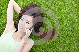 Smiling girl lying down on a meadow and talking