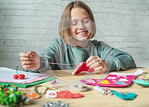 Smiling girl making Christmas felt stocking, Christmas crafting