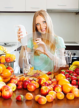 Smiling girl making fruits beverages