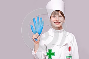 Smiling girl in medical uniform and blue gloves looking at camera isolated on white