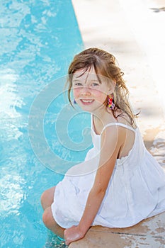 Smiling girl by an outdoor swimming-pool