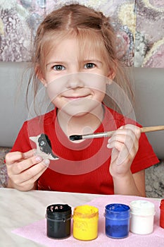 Smiling girl paints crafts