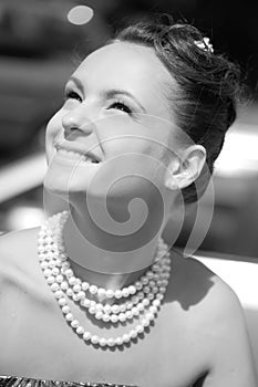 Smiling girl with pearl necklace, monochrome