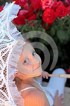 Smiling girl peeks out from under the lace parasol