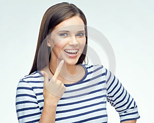 Smiling girl pointing finger on dental braces.