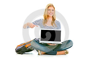 Smiling girl pointing on laptop with blank screen