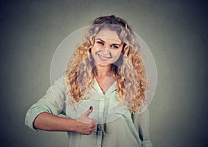 Smiling girl raises right thumb up