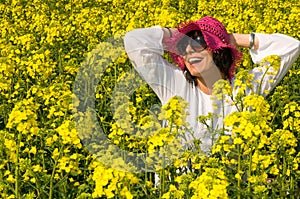 Smiling girl in the rapeseed yellow field