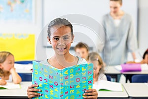 Smiling girl reading book