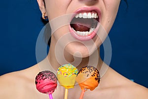 Smiling girl with red, yellow and orange cakepops