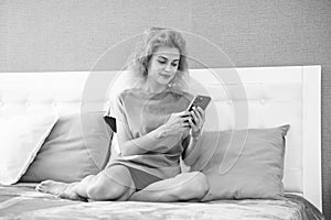 smiling girl relax at home and texting on phone. girl texting on phone on the bed. phone texting