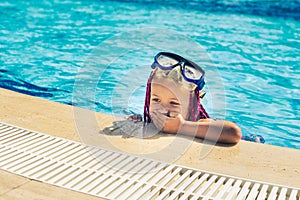 Smiling girl in rose-colored glasses for swimming in the pool