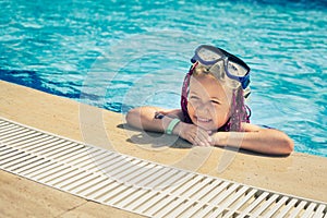 Smiling girl in rose-colored glasses for swimming in the pool