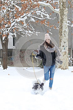 A smiling girl is running whit cute shih tzu dog