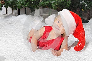 Smiling girl in santa costume on snow