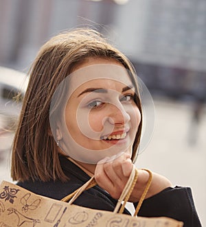 Smiling girl with shopping bags in a city