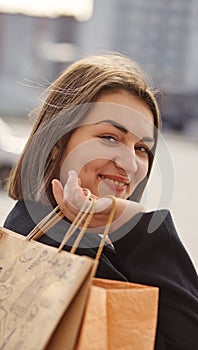 Smiling girl with shopping bags in a city