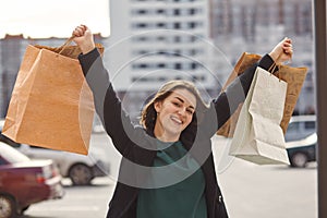 Smiling girl with shopping bags in a city