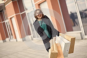 Smiling girl with shopping bags in a city