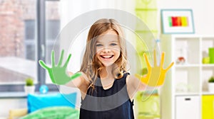 smiling girl showing painted hands at home