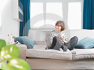 Smiling girl sit relax on couch using modern laptop.happy young woman freelance work on computer from home. social