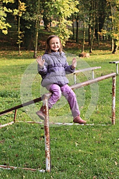 Smiling girl siting on football wicket