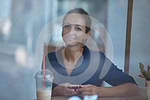 Smiling girl with smartphone. Cup of drink on table. Enjoy life and little moments. Coffee break and leisure time idea