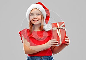 Smiling girl in snata hat with christmas gift