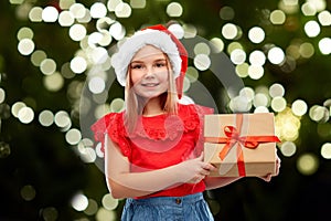 Smiling girl in snata hat with christmas gift