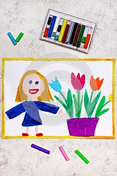 Smiling girl standing nex to flowerpot with tulips