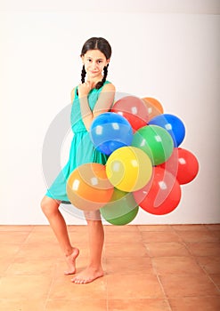 Smiling girl standing posing with inflating balloons