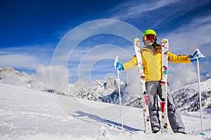 Smiling girl standing with ski and arms spreading wide open on