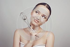 Smiling girl standing on whiter background stainless holding balloon whisk. Happiness and Cheerful young chef Concept. Beautty