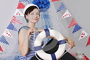 Smiling girl with steering wheel and marine decor