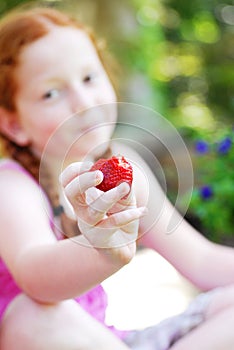 Smiling girl with strawberry