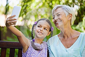 Smiling girl taking selfie with grandmother