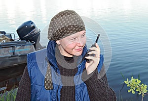 A smiling girl talks on a portable radio set