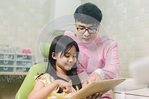 A smiling girl with thumb raised having teeth examination at dental clinic. People, medicine, stomatology and health care concept