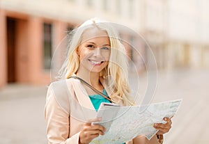 Smiling girl with tourist map in the city