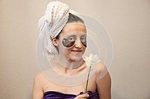 Smiling girl in towel reduce eye bags. skincare. facial collagen cosmetic. moisturizing skin