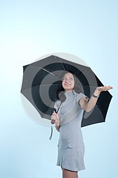 Smiling girl with umbrella checking for rain
