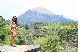 Smiling girl on viewpoint to Merapi volcano