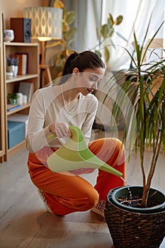 Smiling Girl Watering Potted Palm Tree