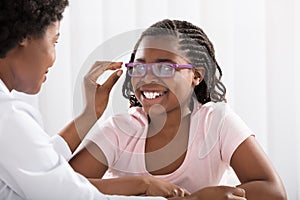 Smiling Girl Wearing Eyeglasses In Front Of Optometrist