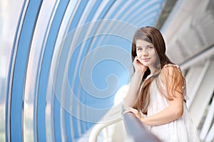 Smiling girl in white blouse stands in long light