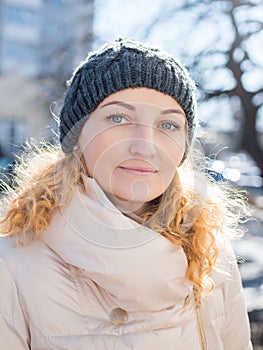 Smiling girl in a white clohtes looking at camera. Young woman winter portrait
