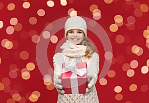 smiling girl in winter clothes with christmas gift