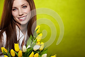 Smiling girl with yellow tulips.